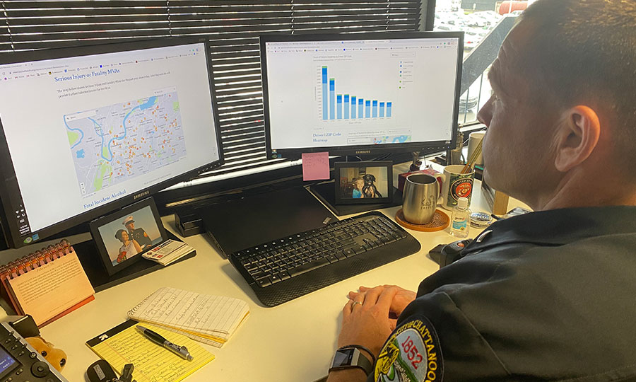 Police officer analyzing traffic accident data on computer monitor