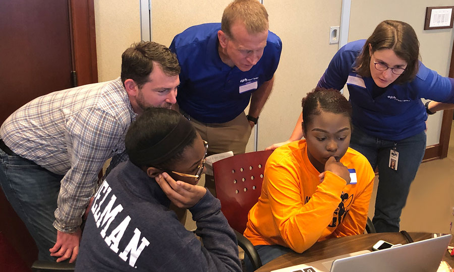 EPB employees helping student on laptop