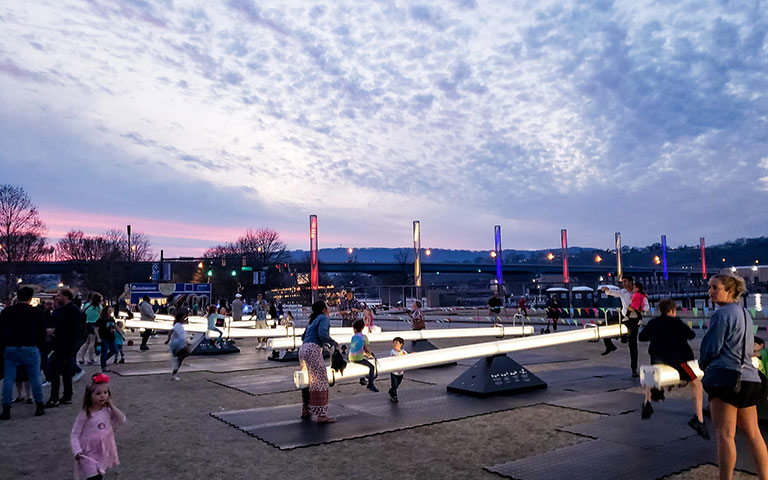 Chattanooga riverfront at dusk with people enjoying art installations