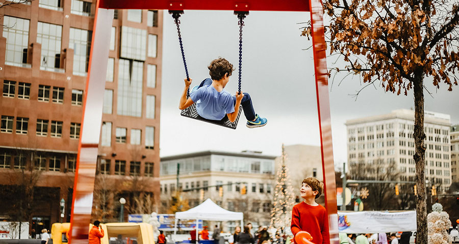 child swinging on art installation