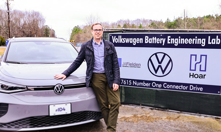 Man standing next to battery powered Volkswagen