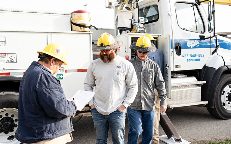 EPB Employees talking in front of a bucket truck