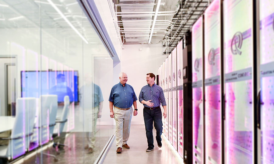 EPB President and CEO walking through hall with computer stacks