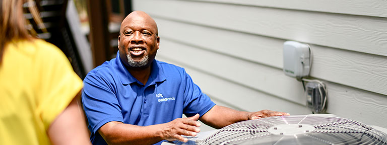 EPB Employee helping customer around an air conditioner unit