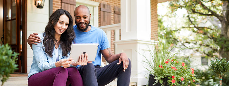 EPB customers setting on steps looking at an iPad