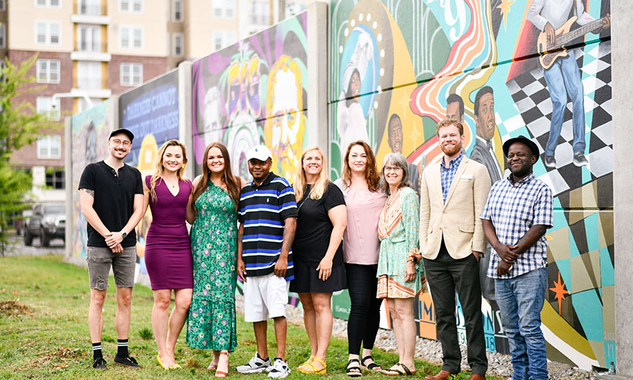 10th street mural project artists standing in front of mural