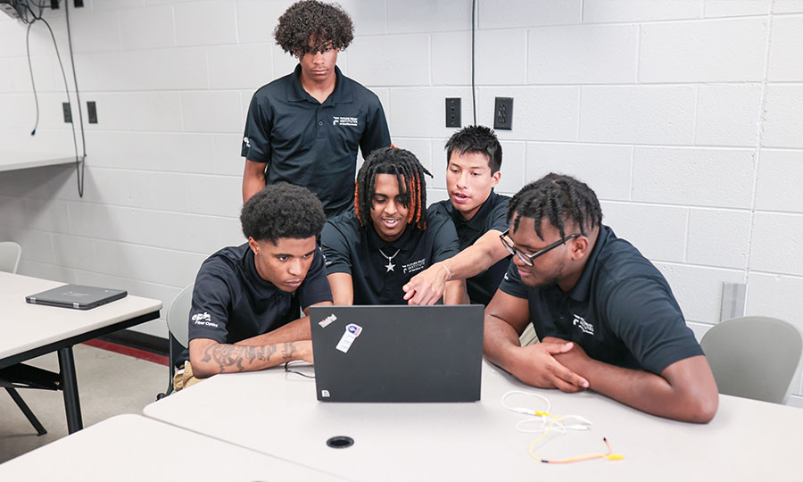 Future Ready Institute students gathered around a laptop
