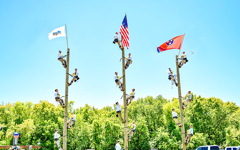 Multiple Linemen climbing up power poles during the Linemen Rodeo